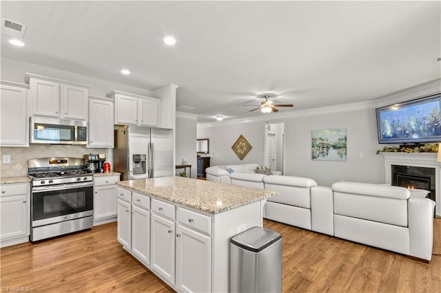 kitchen with backsplash, white cabinetry, ceiling fan, and appliances with stainless steel finishes