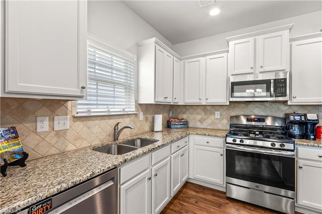 kitchen with white cabinets, sink, appliances with stainless steel finishes, and tasteful backsplash