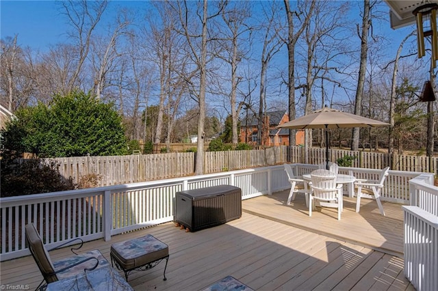 deck with outdoor dining area and a fenced backyard