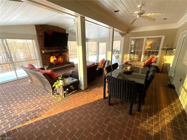 sunroom with ceiling fan, wood ceiling, and a brick fireplace