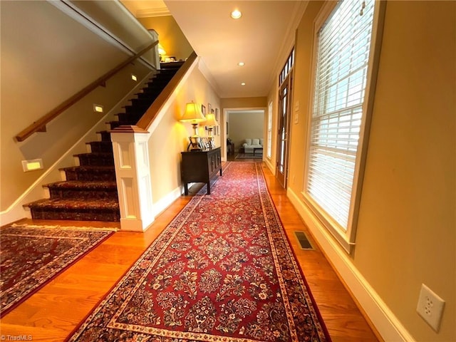 corridor featuring crown molding and hardwood / wood-style floors