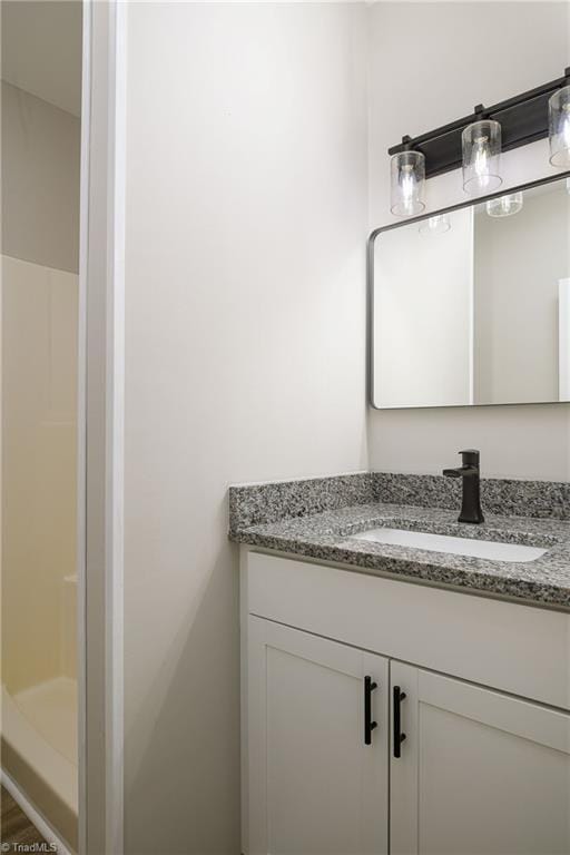 bathroom with vanity, hardwood / wood-style flooring, and walk in shower