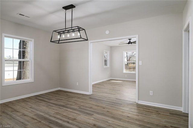 unfurnished dining area featuring dark hardwood / wood-style flooring, plenty of natural light, and ceiling fan