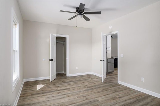 unfurnished bedroom featuring ceiling fan, a closet, and light hardwood / wood-style flooring