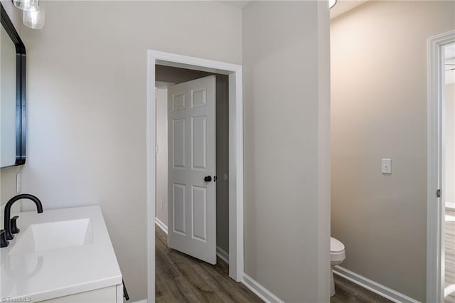 bathroom featuring vanity, wood-type flooring, and toilet