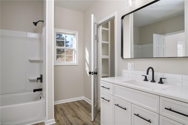 bathroom featuring hardwood / wood-style flooring, vanity, and  shower combination