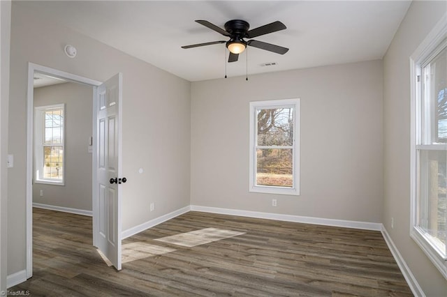 spare room with dark wood-type flooring and ceiling fan