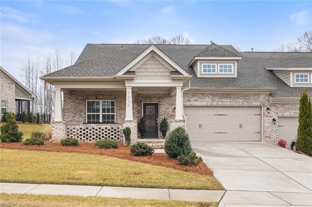 craftsman house featuring a garage and a front lawn