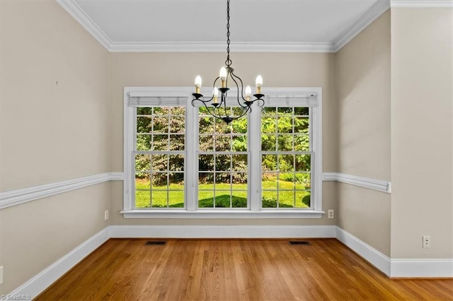 920 James Doak Pkwy, Greensboro, NC 27455 - unfurnished dining area with a chandelier, healthy amount of natural light, wood finished floors, and ornamental molding