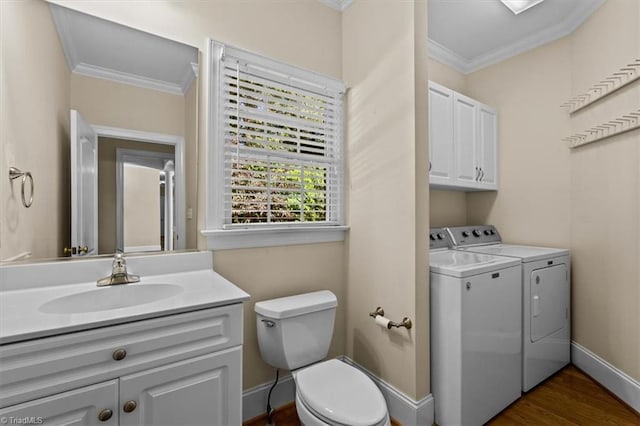 920 James Doak Pkwy, Greensboro, NC 27455 - bathroom with washing machine and clothes dryer, ornamental molding, vanity, and wood finished floors