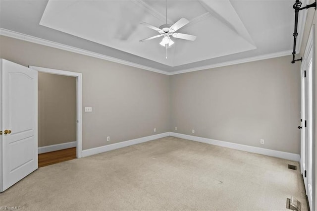 920 James Doak Pkwy, Greensboro, NC 27455 - unfurnished room with light colored carpet, a tray ceiling, a ceiling fan, and crown molding