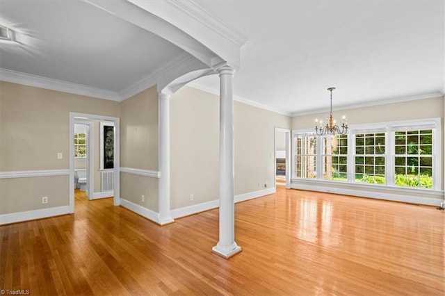 920 James Doak Pkwy, Greensboro, NC 27455 - unfurnished living room featuring decorative columns, wood finished floors, a chandelier, and crown molding