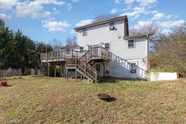 back of house featuring a lawn and a deck