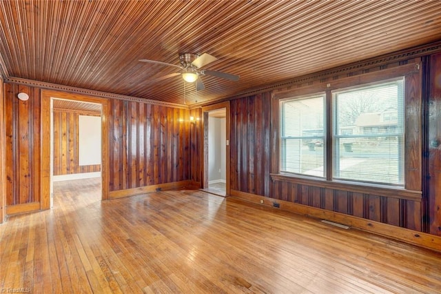 unfurnished room with wood walls, ceiling fan, and hardwood / wood-style flooring