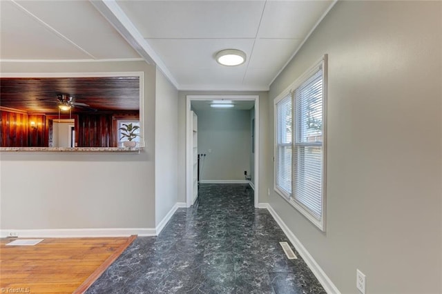 hall with crown molding, visible vents, and baseboards