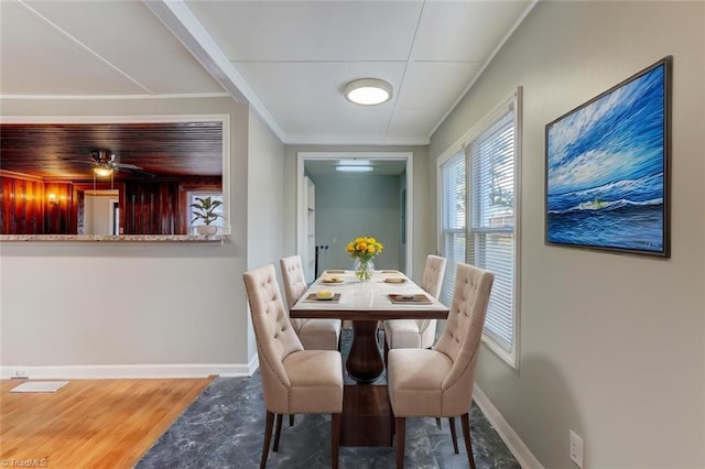 dining area with baseboards, wood finished floors, and ornamental molding