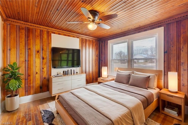 bedroom featuring wooden ceiling, wood finished floors, wood walls, and ceiling fan