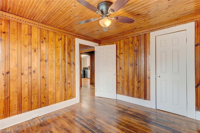 spare room featuring wooden walls, wood ceiling, baseboards, and wood finished floors