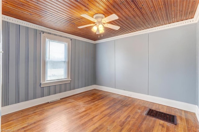 unfurnished room with visible vents, a ceiling fan, baseboards, and wood finished floors