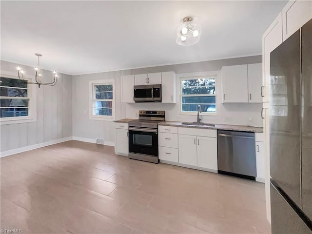 5622 Ruth Ave, Winston-Salem, NC 27105 - kitchen featuring white cabinetry, sink, stainless steel appliances, and decorative light fixtures