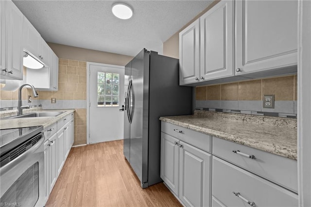 131 Springdale Dr, Stoneville, NC 27048 - kitchen featuring white cabinetry, appliances with stainless steel finishes, a sink, and light wood-type flooring