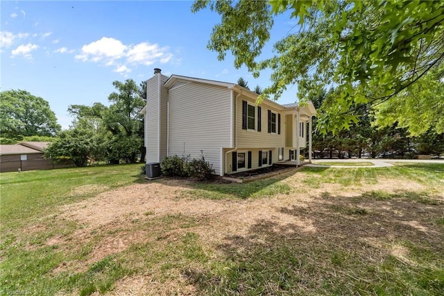 131 Springdale Dr, Stoneville, NC 27048 - view of side of home featuring a lawn, a chimney, and central AC