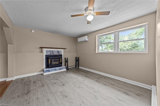 131 Springdale Dr, Stoneville, NC 27048 - unfurnished living room with wood finished floors, baseboards, ceiling fan, an AC wall unit, and a textured ceiling