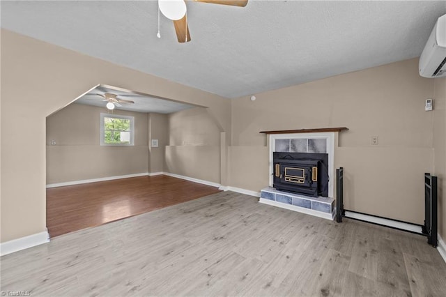131 Springdale Dr, Stoneville, NC 27048 - unfurnished living room with baseboards, a ceiling fan, a wall unit AC, and wood finished floors