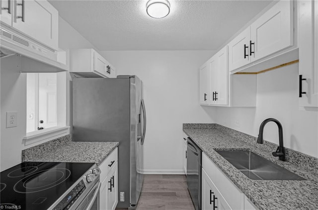 kitchen with dark wood-type flooring, white cabinets, appliances with stainless steel finishes, and a sink