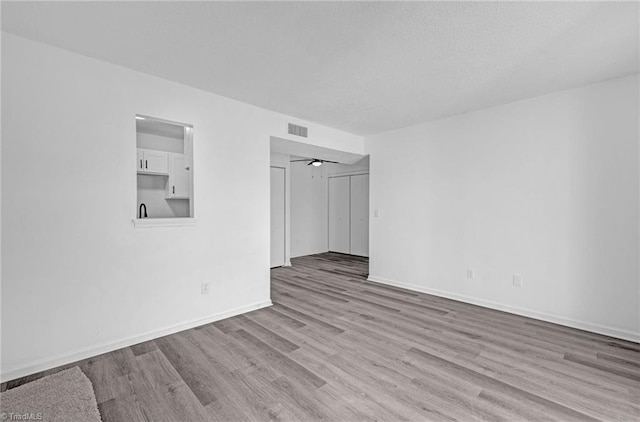 unfurnished room featuring visible vents, baseboards, and wood finished floors