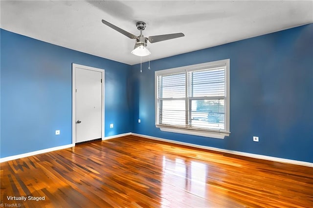 empty room with hardwood / wood-style floors and ceiling fan