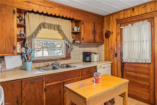 kitchen featuring white dishwasher, sink, and backsplash