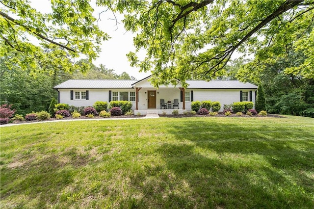 single story home with a porch, metal roof, and a front lawn