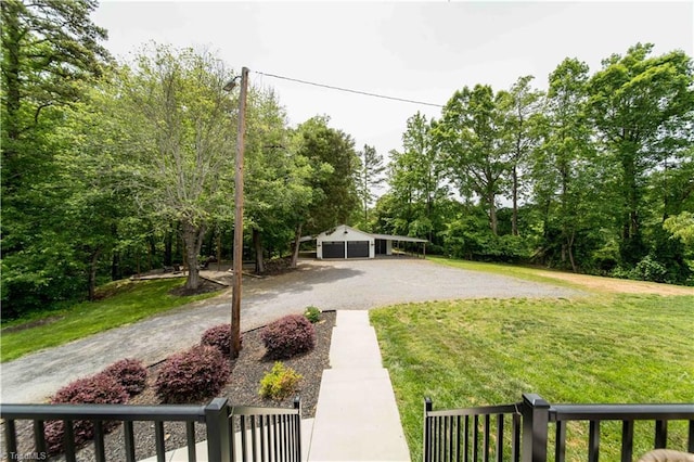 view of grassy yard featuring a garage and driveway