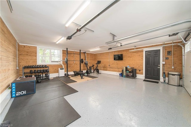 garage with wood walls and a garage door opener