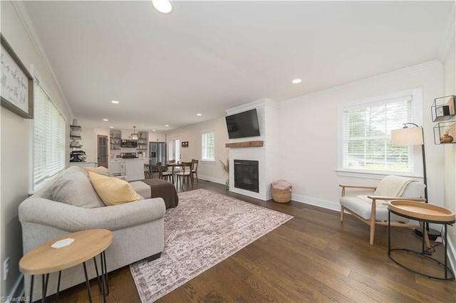 living room with ornamental molding, baseboards, dark wood-type flooring, recessed lighting, and a large fireplace