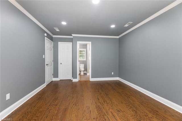 interior space featuring ornamental molding, ensuite bathroom, and dark hardwood / wood-style flooring