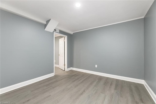 empty room featuring ornamental molding and light hardwood / wood-style floors