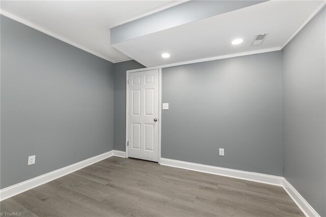 empty room featuring hardwood / wood-style flooring and crown molding