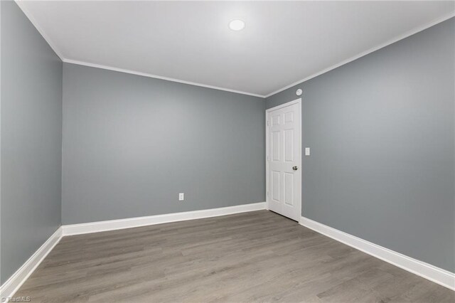 empty room with wood-type flooring and ornamental molding