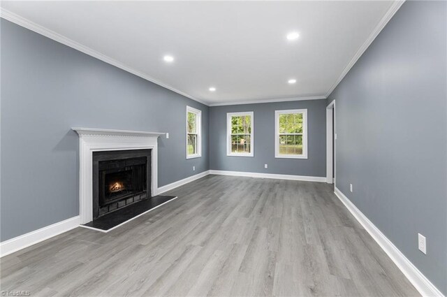 unfurnished living room with light hardwood / wood-style floors and crown molding