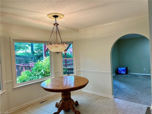 3501 River Ridge Rd, Pfafftown, NC 27040 - dining space with arched walkways, a textured ceiling, light tile patterned floors, crown molding, and baseboards