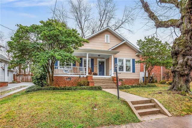 bungalow featuring covered porch and a front yard