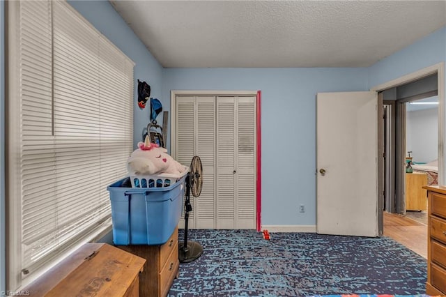 bedroom with dark hardwood / wood-style flooring, a closet, and a textured ceiling