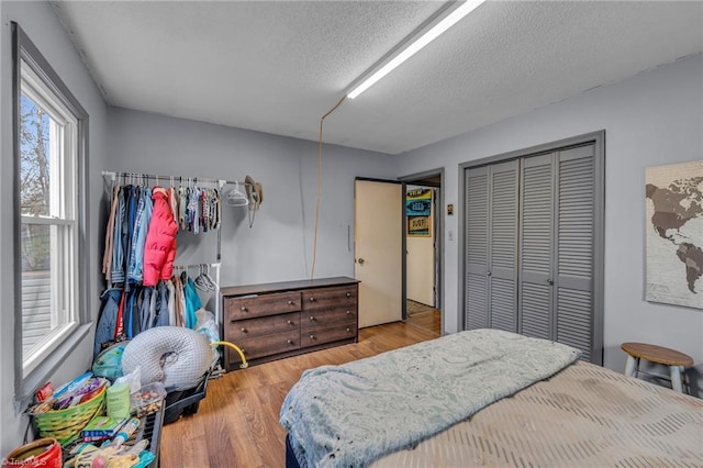 bedroom featuring a closet, a textured ceiling, and hardwood / wood-style flooring