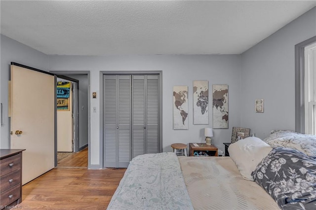 bedroom featuring a textured ceiling, a closet, and light wood-type flooring