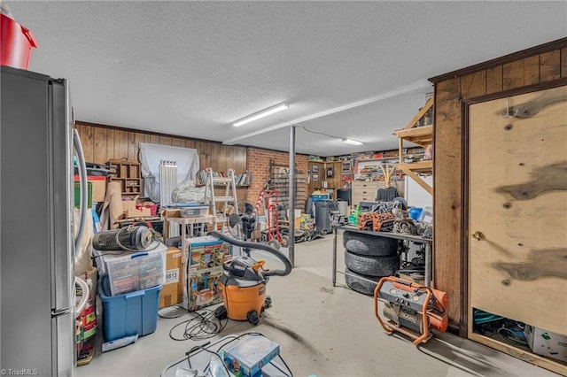 interior space featuring wood walls and stainless steel fridge