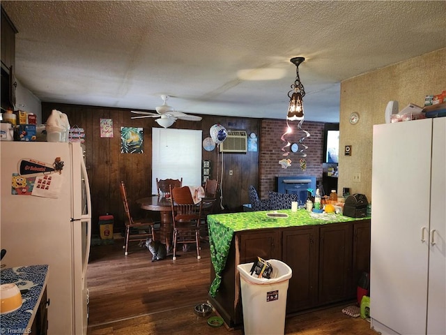 kitchen featuring white fridge, dark brown cabinets, dark hardwood / wood-style floors, hanging light fixtures, and ceiling fan