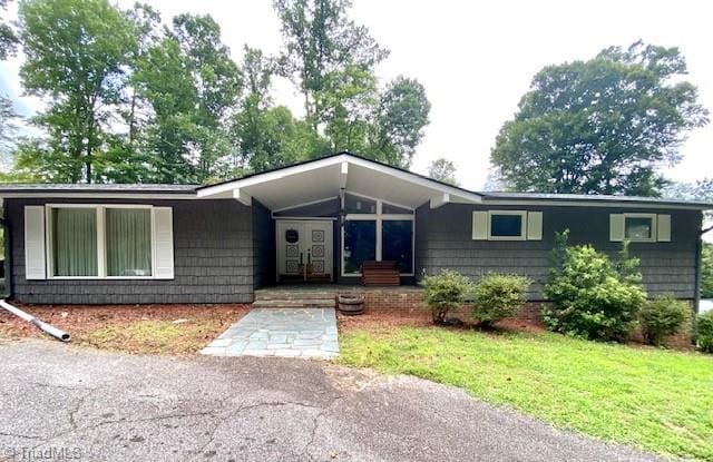 ranch-style home featuring a front lawn