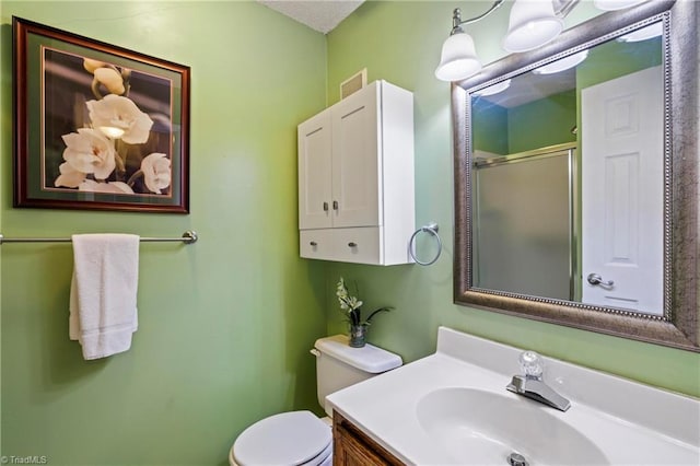 bathroom featuring toilet, an enclosed shower, and vanity